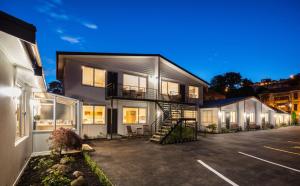 ein Haus mit einer Treppe auf einem Parkplatz in der Unterkunft Beechwood Boutique Accommodation in Dunedin