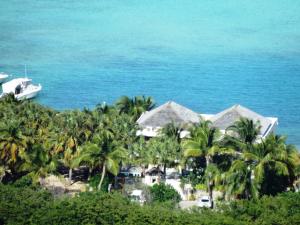 einen Luftblick auf ein Resort mit Palmen und einem Boot in der Unterkunft Hotel Les Ondines Sur La Plage in Gustavia