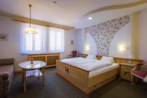 1 dormitorio con 1 cama grande y 1 mesa en Das-Schmidt Privathotel, en Mörbisch am See