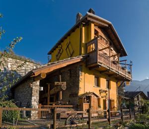 Una casa antigua con un balcón encima. en B&B Il Torchio, en Saint Vincent