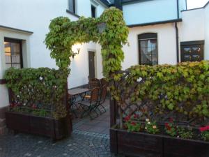 um arco com plantas e uma mesa em frente a um edifício em Hotel Restaurant Zur Pfanne em Koblenz