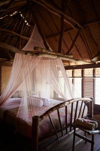 una camera con letto a baldacchino e zanzariere di The Island Houses Bingin a Uluwatu