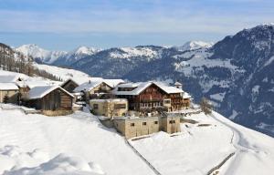 un bâtiment au sommet d'une montagne enneigée dans l'établissement Hotel Restaurant Capricorns, à Wergenstein