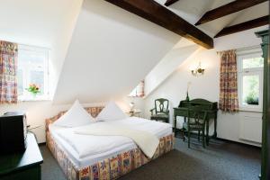 een slaapkamer met een bed, een bureau en een piano bij Hotel Forsthaus in Bad Schandau