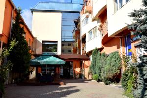 a building with a green umbrella in a courtyard at Hotel Premier in Cluj-Napoca