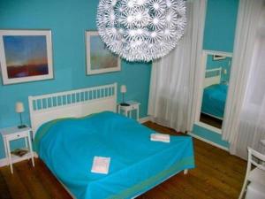 um quarto azul com uma cama e um lustre em Hemingway`s Heidelberg Hostel em Heidelberg