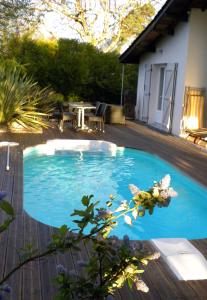 einen kleinen blauen Pool auf einer Holzterrasse in der Unterkunft Villa Mogador Piscine et Balnéo in Andernos-les-Bains