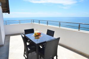 a table and chairs on a balcony with the ocean at Villa Marinero in Ulcinj