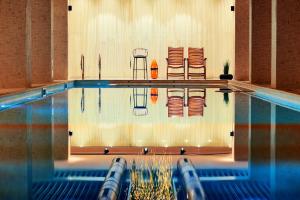 uma piscina com cadeiras e ools nela em Lucky Bansko Aparthotel SPA & Relax em Bansko