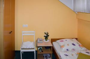 1 dormitorio con cama, escritorio y escalera en Penzion Gostilna Keber, en Domžale