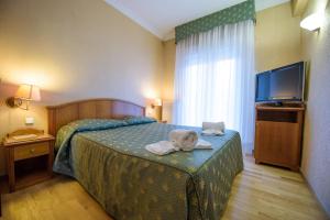 Hotel Kastoria in Kastoria City في كاستوريا: غرفة فندق عليها سرير وفوط