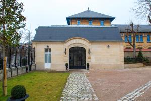 a building with a black roof and a gate at Les Suites du Champagne de Venoge in Épernay