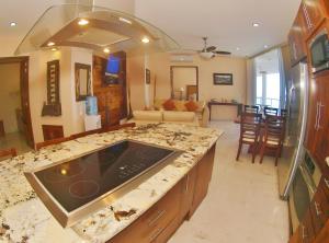 a kitchen with a counter top and a living room at Mondavi in Puerto Vallarta