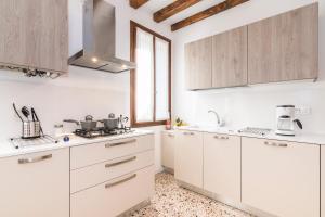 a white kitchen with white cabinets and a window at Cà Boldo Terrace 2.0 in Venice