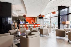 a restaurant with chairs and tables and a bar at Hotel ParkSaône in Lyon