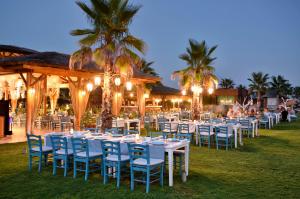 un groupe de tables et de chaises devant un bâtiment dans l'établissement Regnum Carya, à Belek