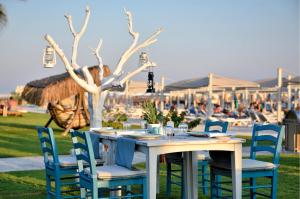 - une table à manger et des chaises avec vue sur la plage dans l'établissement Regnum Carya, à Belek