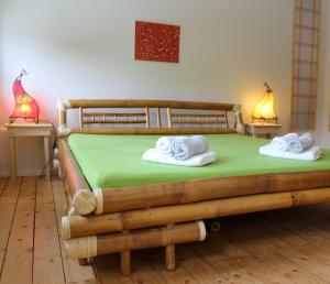 ein Schlafzimmer mit einem Holzbett mit Handtüchern darauf in der Unterkunft Villa Viriditas in Elbingerode