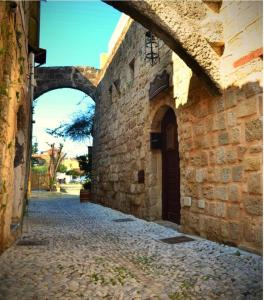 eine Gasse mit einem Torbogen in einem Steingebäude in der Unterkunft Petrino in Rhodos (Stadt)