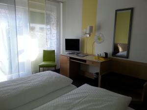 - une chambre avec un bureau, un ordinateur et un lit dans l'établissement Hotel Garni Sand, à Tübingen