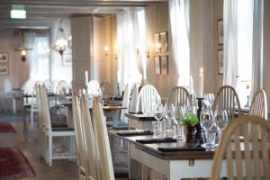 a dining room with tables and chairs with wine glasses at Skanörs Gästgifvaregård in Skanör med Falsterbo