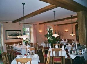 un comedor con mesas y sillas blancas en Landhaus Heidehof, en Dippoldiswalde