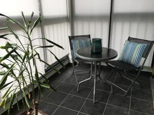 een kleine tafel en 2 stoelen op een patio bij Cozy and Bright Apartment in Machico