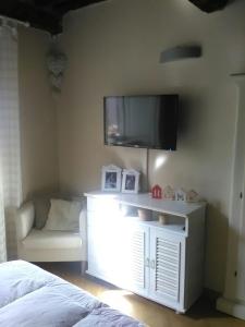 1 dormitorio con TV en la pared y sofá en Suite Sofia, en Lucca