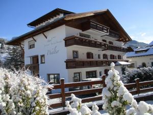 un grande edificio bianco con tetto in legno di Hotel Garni Walter a Ortisei