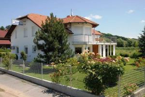 une maison blanche avec une clôture devant elle dans l'établissement Apartments Villa Split, à Krapinske Toplice