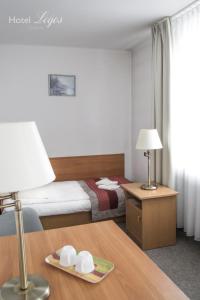 a hotel room with a bed and a table with a lamp at Hotel Logos in Lublin