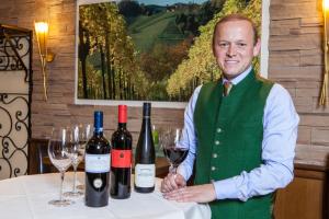 un homme debout à côté d'une table avec des verres à vin dans l'établissement Gasthof Engelhof, à Gmunden