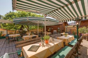 un patio extérieur avec des tables et des parasols dans l'établissement Gasthof Engelhof, à Gmunden