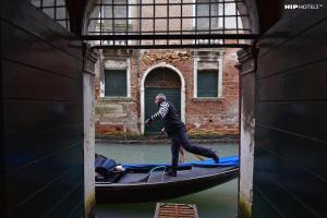 een man op een gondel in een kanaal bij Charming House Iqs in Venetië