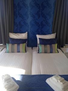 a bedroom with two beds with blue walls at The Riverside Logies & Restaurant in Maarssen