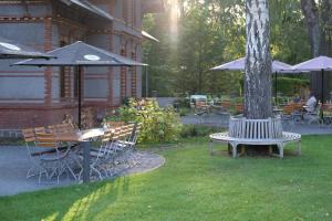 een tafel en stoelen met een parasol naast een boom bij Forsthaus Sommerswalde in Sommerswalde