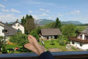 uma pessoa sentada num parapeito a olhar para uma casa em Gasthof Feichter em Finkenstein