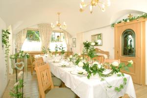 uma sala de jantar com uma mesa longa com flores em Gasthof Feichter em Finkenstein