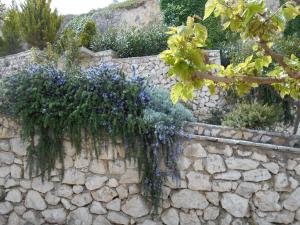 a stone wall with purple flowers on it at Zephyros Rooms And Apartments in Drymon