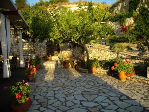 a stone walkway with flowers and plants in pots at Zephyros Rooms And Apartments in Drymon