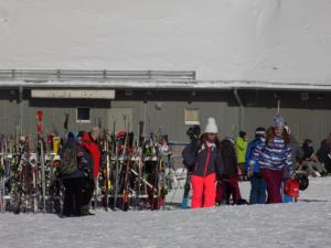 un groupe de personnes debout devant un bâtiment avec des skis dans l'établissement Gîte Esprit Follet, à Baie-Saint-Paul