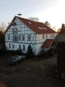 una casa con un coche aparcado delante de ella en Oldenstadter Wassermuhle, en Uelzen