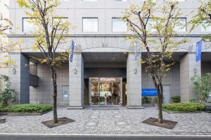 dos árboles frente a un edificio en HOTEL MYSTAYS PREMIER Omori, en Tokio