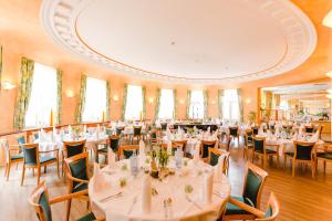 a banquet hall with white tables and chairs at Kurhotel Fürstenhof by David in Blankenburg