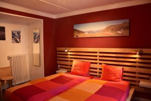 una camera da letto con un letto con cuscini arancioni di Adventure Hostel a Klosters