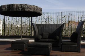 un fauteuil et un pouf sur un balcon avec une clôture dans l'établissement YOOMA Urban Lodge, à Bruxelles