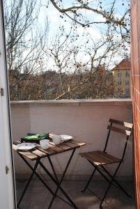 een tafel en stoelen op een balkon met een raam bij Szamóca Apartman in Szeged