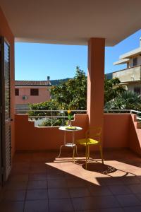 een patio met een tafel en 2 stoelen op een balkon bij Casa Vacanze Mura in Cala Gonone