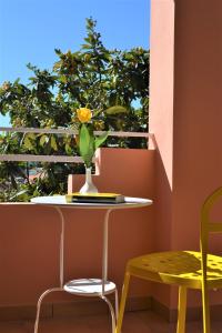 een vaas met een bloem op een tafel naast een raam bij Casa Vacanze Mura in Cala Gonone