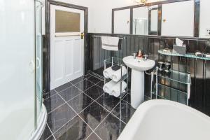 a bathroom with a sink and a teddy bear sitting in a chair at Gumnut House. in Whanganui